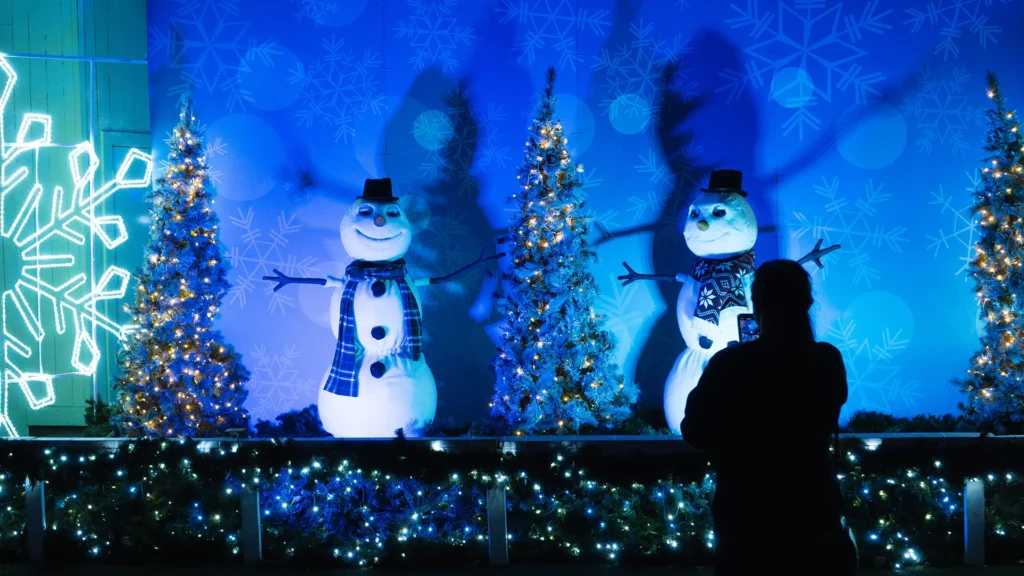 Snowmen and Christmas trees illuminated at night